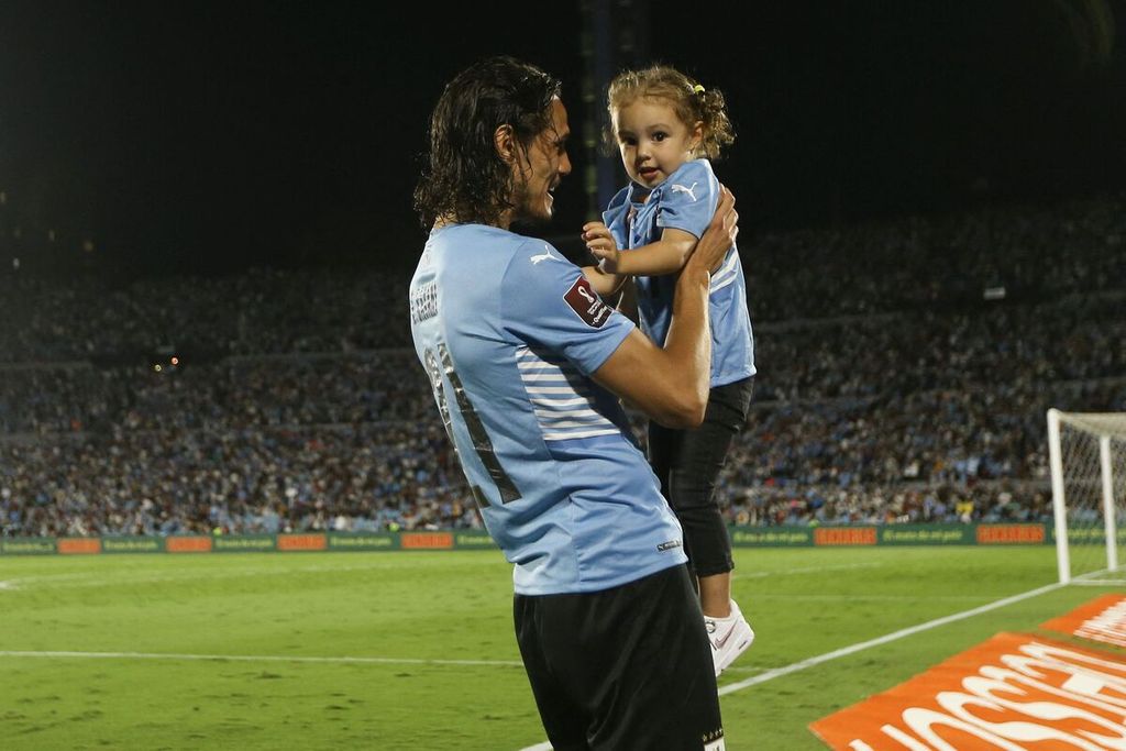 Pemain Uruguay, Edinson Cavani menggendong putrinya setelah pertandingan pertandingan kualifikasi Piala Dunia Qatar zona Amerika Selatan, antara Uruguay dan Venezuela, di Stadion Centenario, Montevideo, Uruguay, Rabu (2/2/2022) WIB. Pertandingan berakhir dengan skor 4-1 untuk kemenangan Uruguay.