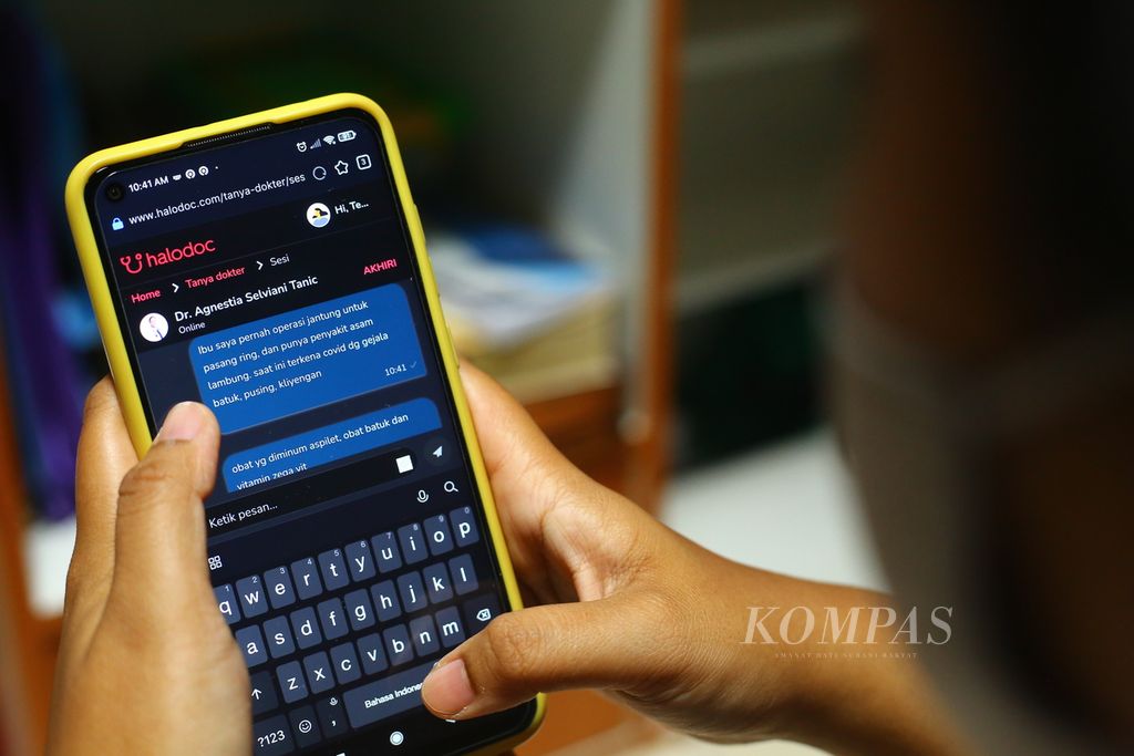 Penderita Covid yang menjalani isolasi mandiri memanfaatkan fasilitas <i>telemedicine</i> menggunakan telepon genggamnya dari rumahnya di Tangerang Selatan, Senin (31/1/2022). 
