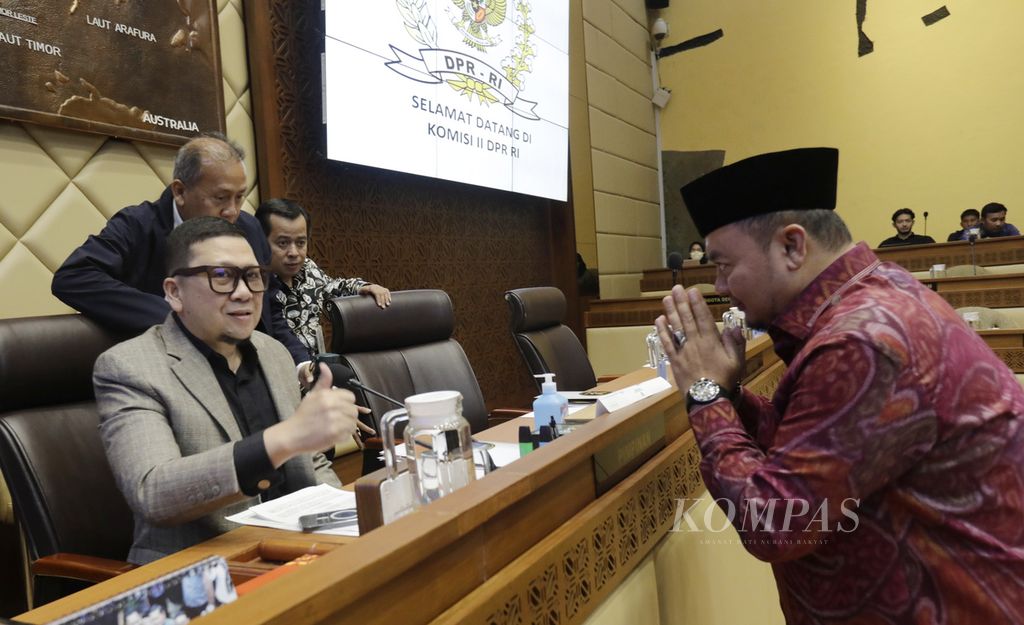 Ketua KPU Mochammad Afifuddin (kanan) menyapa Ketua Komisi II DPR Ahmad Doli Kurnia saat menghadiri rapat dengar pendapat dengan Komisi II DPR tentang penetapan revisi PKPU Nomor 8 Tahun 2024 terkait keputusan Mahkamah Konstitusi di Kompleks Parlemen, Senayan, Jakarta, Minggu (25/8/2024). 