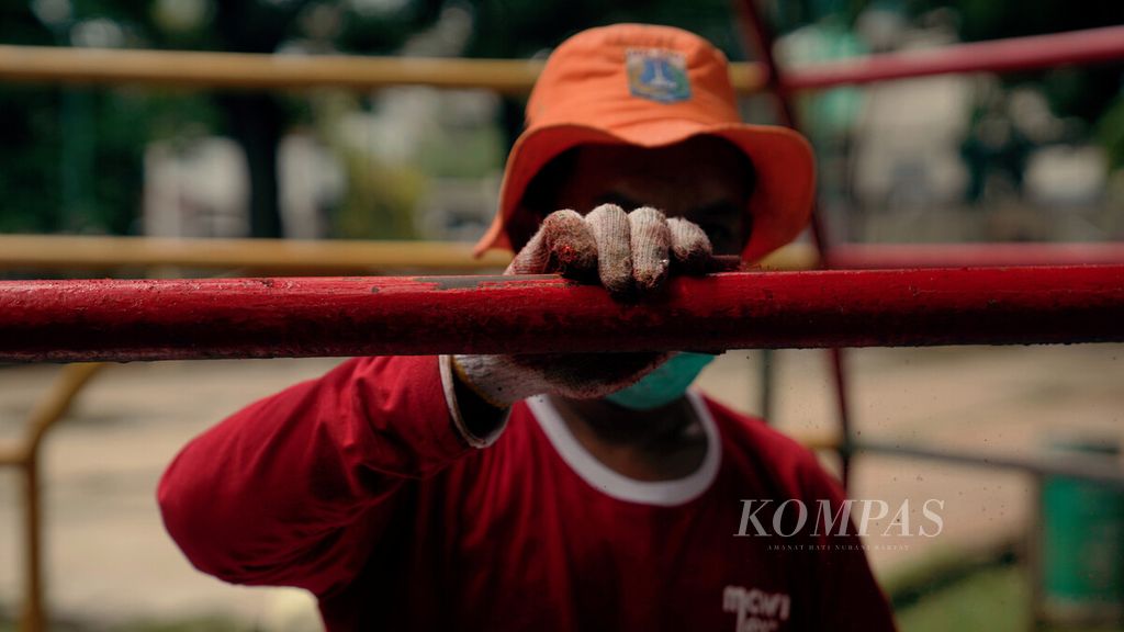 Pekerja mengelupas cat sebelum mengecat ulang kembali di Ruang Publik Terpadu Ramah Anak (RPTRA) Amir Hamzah, Pegangsaan, Menteng, Jakarta Pusat, Kamis (28/10/2021). 