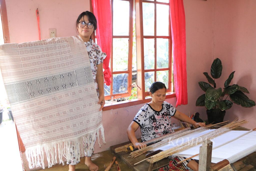 Irawati Simorangkir (32) dan Nurmasito Sihombing (38) menenun ulos di Desa Enda Portibi, Kecamatan Siatas Barita, Kabupaten Tapanuli Utara, Sumatera Utara, Selasa (12/10/2021). 
