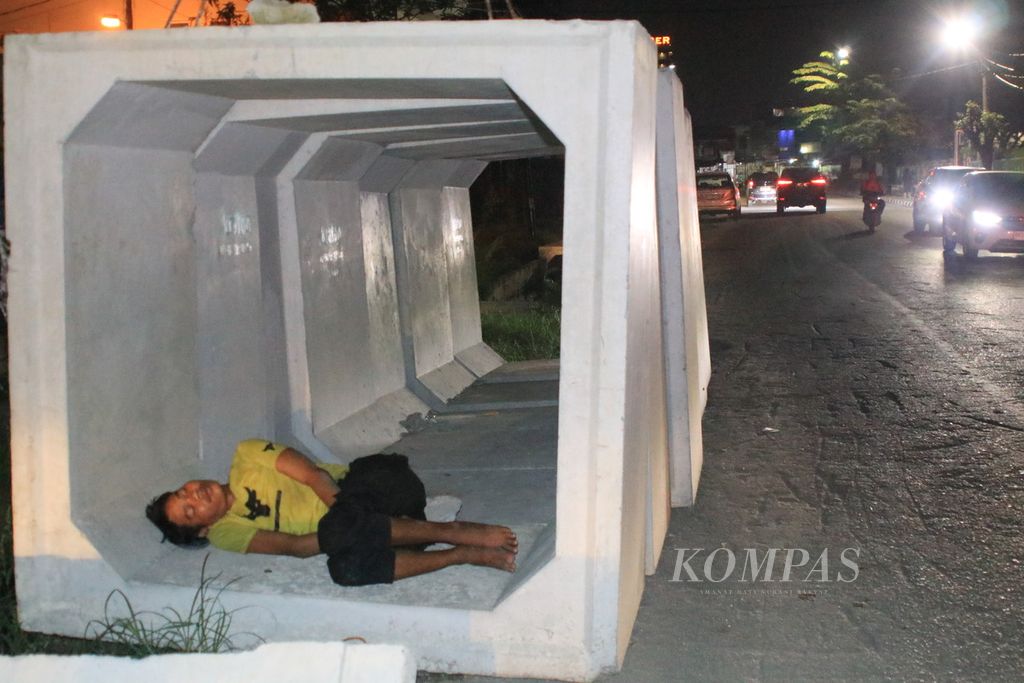 Seorang tunawisma tidur di bawah beton drainase yang belum dipasang di proyek pembangunan drainase di Jalan KH Wahid Hasyim, Medan, Sumatera Utara, Rabu (8/11/2023). 