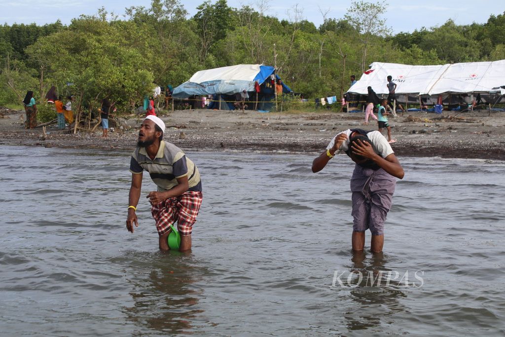 Pengungsi Rohingya berwudhu di tepi pantai sebelum shalat di kamp pengungsian darurat di Desa Karang Gading, Kecamatan Labuhan Deli, Kabupaten Deli Serdang, Sumatera Utara, Rabu (17/1/2024).