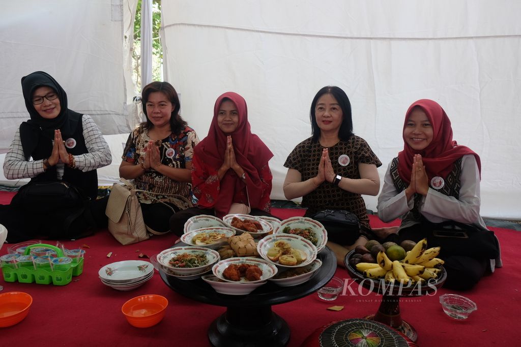 Warga lintas agama menikmati hidangan ketupat pada tradisi Lebaran Topat di makam Bintaro, Ampenan, Kota Mataram, 2019.