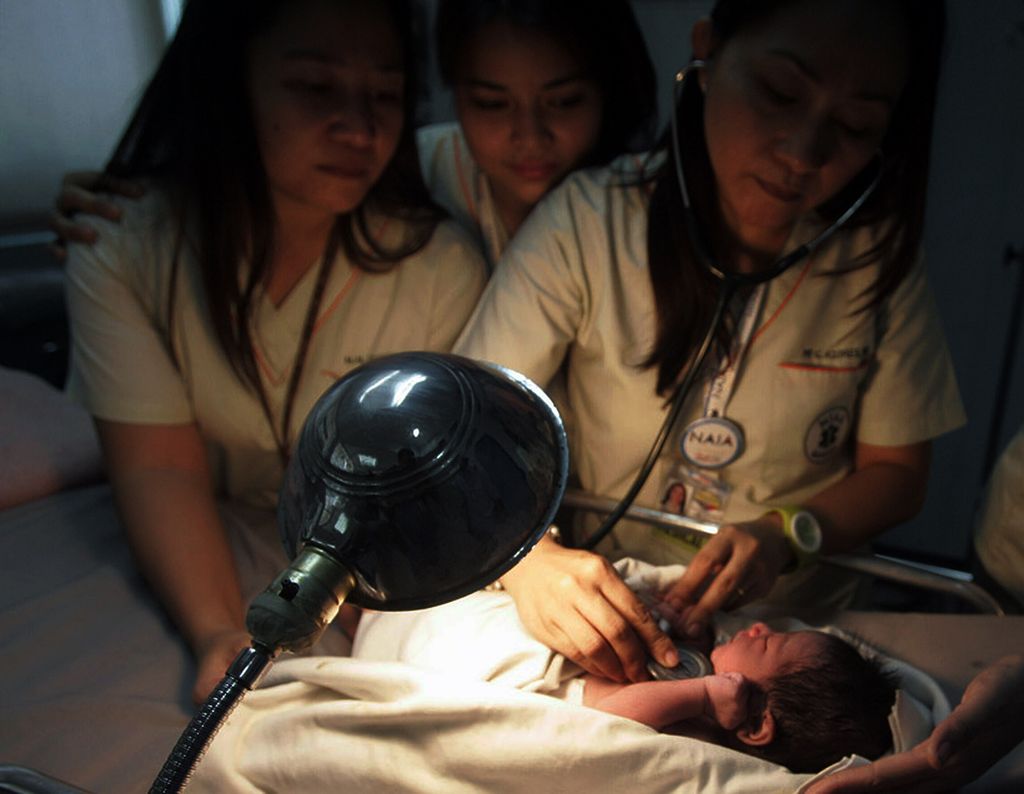 Dalam arsip foto 12 September 2010 ini terlihat perawat merawat bayi baru lahir yang ditemukan di dalam toilet pesawat di bandara internasional Manila, Filipina. Awak darat yang membersihkan pesawat Gulf Air yang baru saja mendarat dari Bahrain menemukan bayi tersebut di dalam salah satu toilet pesawat. 
