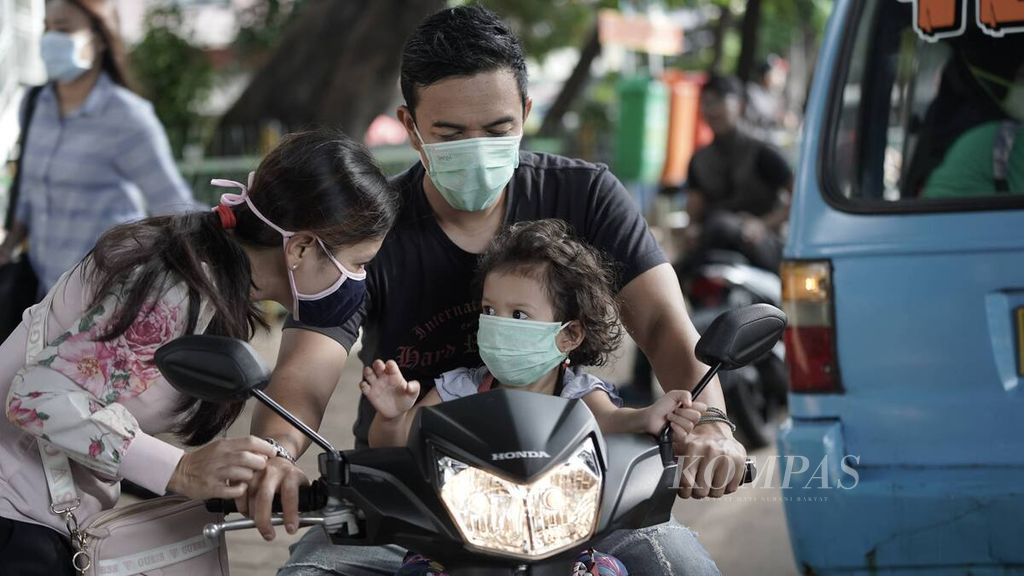Seorang ibu berpamitan dengan anaknya yang memakai masker di sekitar Stasiun Tebet, Jakarta Selatan, Rabu (8/4/2020). DKI Jakarta resmi menerapkan pembatasan sosial berskala besar (PSBB) mulai Jumat, 10 April 2020. 