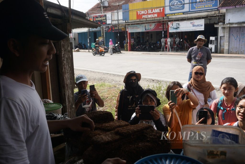 Peserta Prembun Heritage Walk bertema “Jelajah Lawang Wetan” melihat jenis tembakau di kios tembakau di Prembun, Kebumen, Jawa Tengah, Sabtu (24/9/2022). 