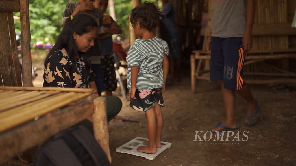 Ahli gizi Imelda Tamo Inya (kiri) mengukur berat badan Aderensi (4) saat kunjungan ke rumah pada Kamis (10/11/2022) di Kodi, Sumba Barat Daya, Nusa Tenggara Timur.