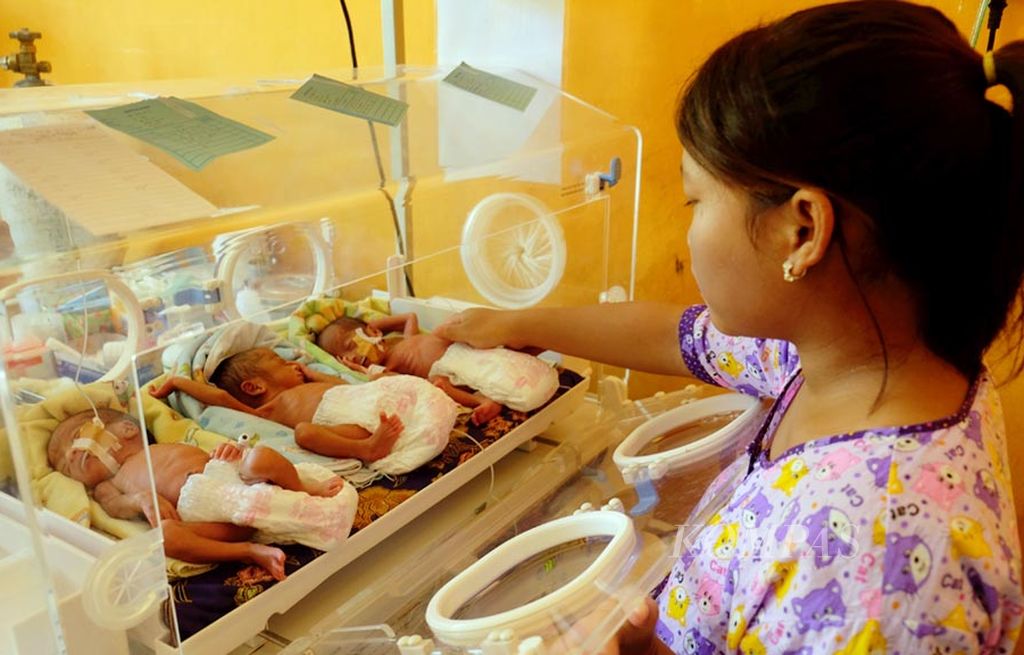 Ruth Katawarina (17) menjaga ketiga anaknya yang masih berada di dalam inkubator di ruang Perinatologi Rumah Sakit Umum Daerah Sungai Dareh, Kabupaten Dharmasraya, Sumatera Barat, Sabtu (8/7). Ruth melahirkan ketiga anaknya lewat operasi sesar pada Jumat (23/6).