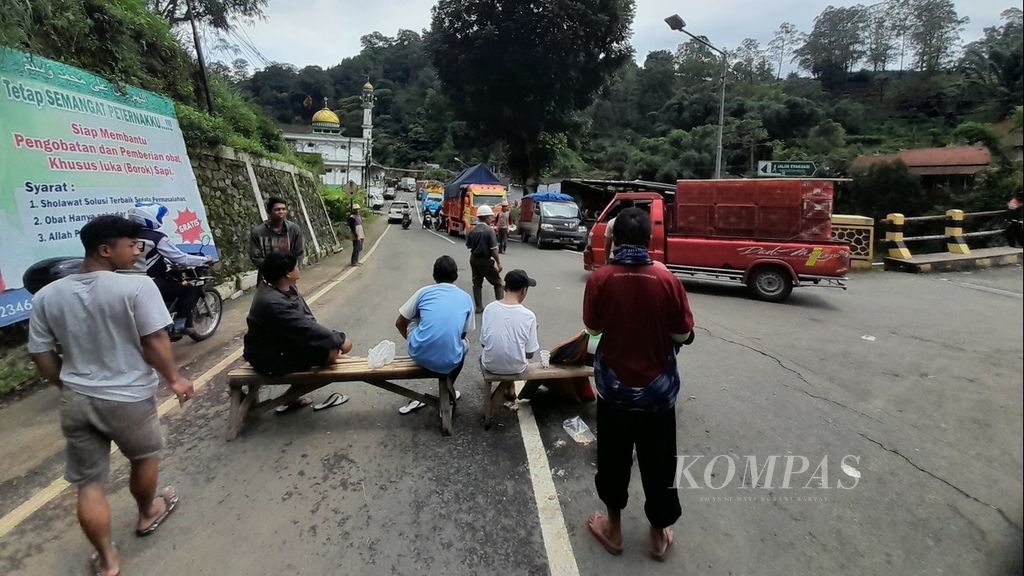 Arus kendaraan kecil dialihkan melalui jalan alternatif, Rabu (1/3/2023), akibat jalur utama Malang-Kediri di Desa Sukomulyo, Kecamatan Pujon, Kabupaten Malang, Jawa Timur, longsor.