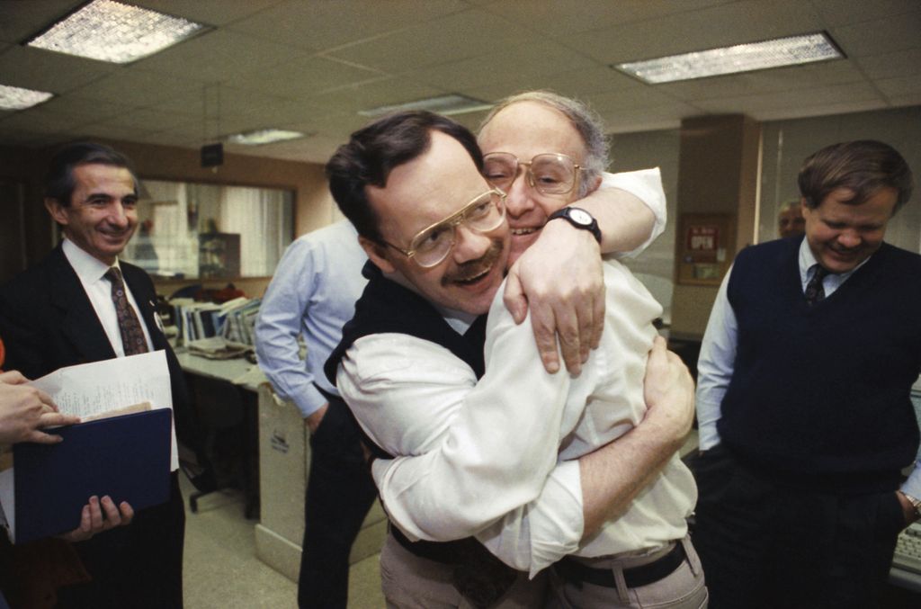 Terry Anderson, jurnalis kantor berita AP (kiri, berkacamata), memeluk rekannya, Jim Abrams, saat berkunjung ke biro kantor berita AP di Washington, 12 Desember 1991. 