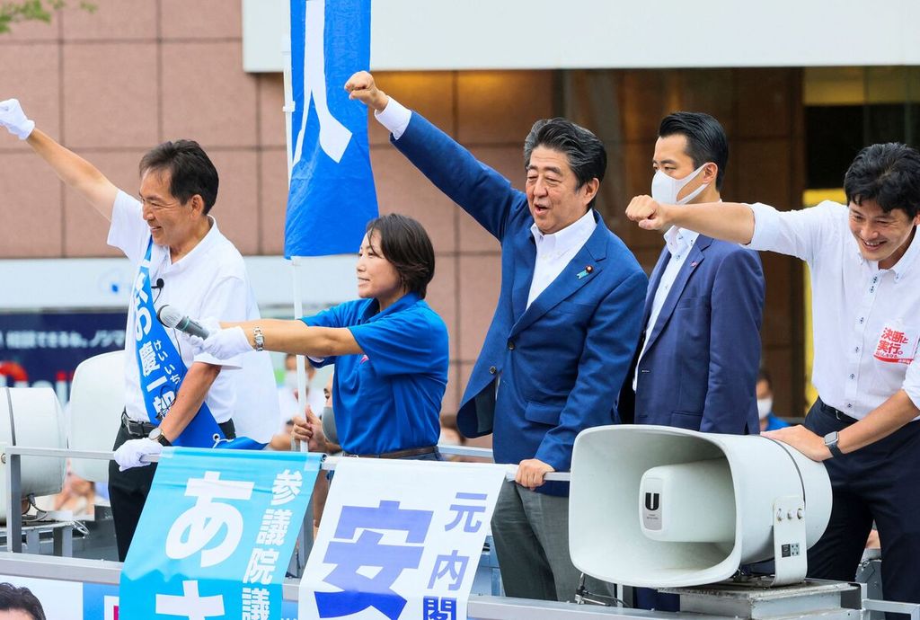 Foto yang diambil pada 6 Juli 2022 ini memperlihatkan mantan PM Jepang Shinzo Abe (tengah) mengangkat tangan dalam kampanye menjelang pemilu Majelis Tinggi Parlemen Jepang di Yokohama, wilayah suburban Tokyo, Jepang. 