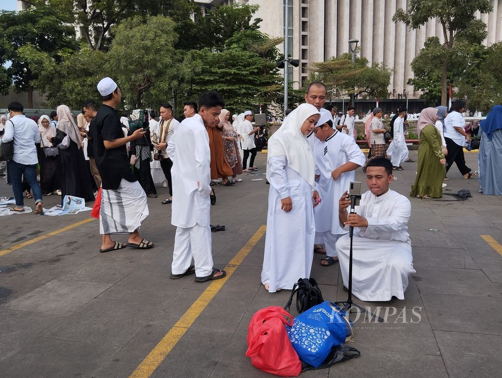 Sebagian umat Islam berfoto di halaman Masjid Istiqlal, Jakarta, seusai Shalat Idul Fitri, Rabu (10/4/2024) pagi.