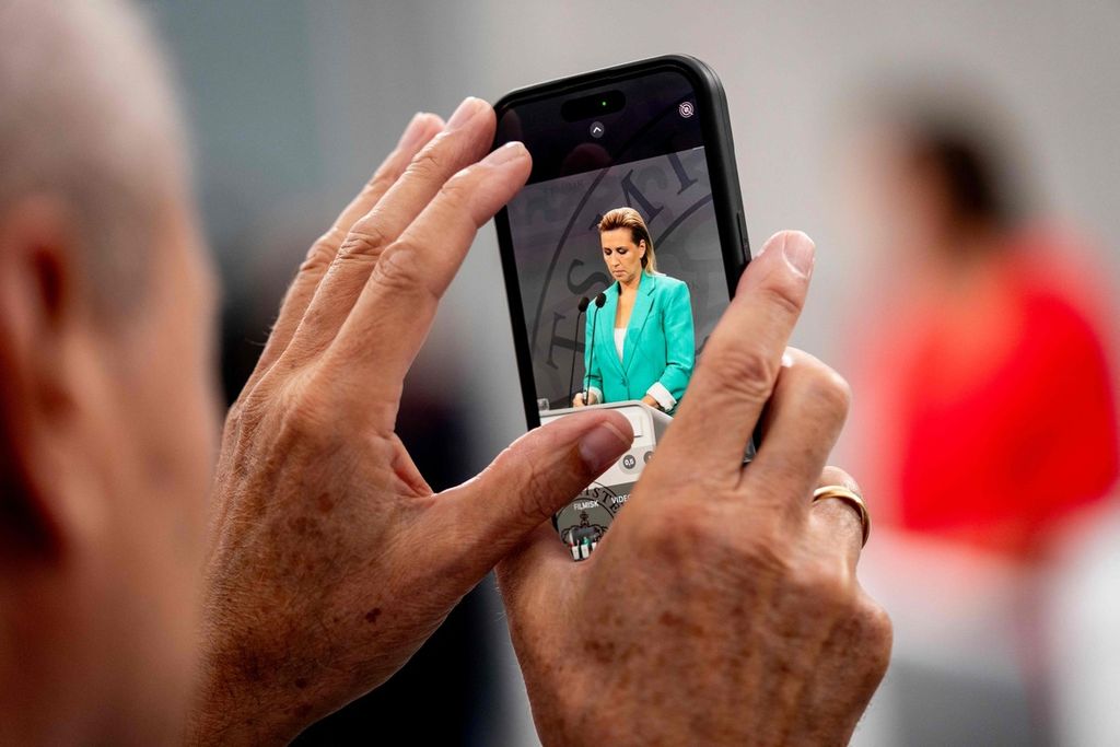 Perdana Menteri Denmark Mette Frederiksen terlihat di layar telepon genggam saat ia berpidato dalam sebuah konferensi pers di kantor PM di Kopenhagen, Denmark, 18 September 2024.