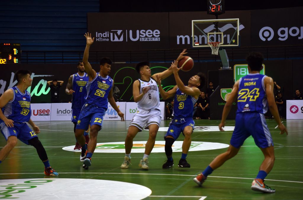 Duel perebutan bola antara pemain Mountain Gold, William Beckham Mamahit Pontoh (putih), dan pemain Prawira Harum Bandung, Teemo Teemo, pada laga seri keenam Liga Bola Basket Indonesia (IBL) 2023 di GOR Amongraga, Yogyakarta, Rabu (24/5/2023). Prawira menang telak 108-62. 