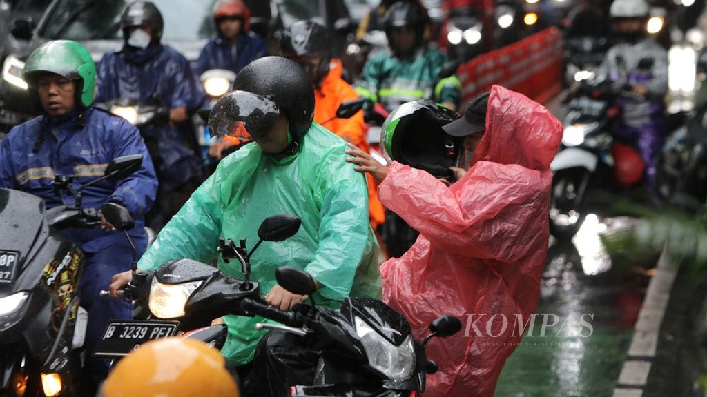 Tukang ojek bersiap mengantar penumpang saat hujan deras di Jalan Tentara Pelajar, di sekitar Stasiun Palmerah, Jakarta, Selasa (21/2/2023). 