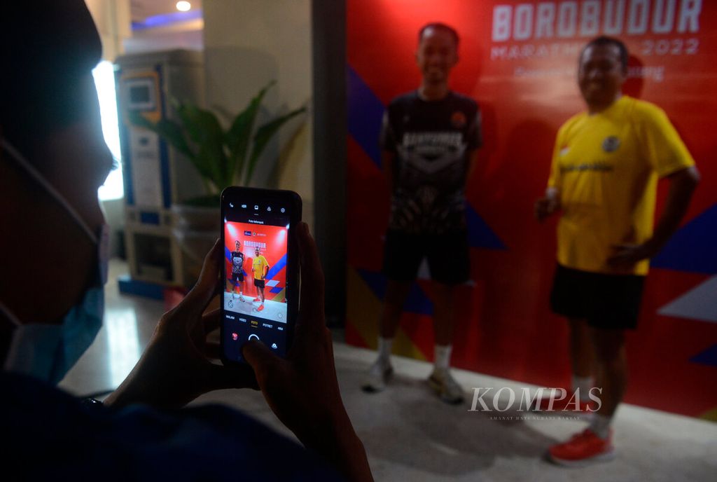 Peserta lari sore berfoto di depan logo Borobudur Marathon saat peluncuran kembali penyelenggaraan Borobudur Marathon 2022 di Kantor Bank Jateng, Kota Semarang, Jawa Tengah, Minggu (22/5/2022).
