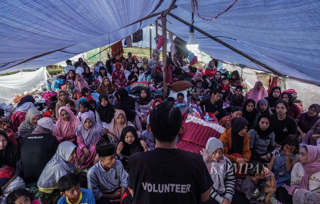 Suasana saat sukarelawan dari Dompet Dhuafa memberikan pelayanan penanganan awal psikologi bagi para korban gempa di tenda pengungsian RT 005 RW 004 Kampung Panyaweuyan, Pacet, Kabupaten Cianjur, Jawa Barat, Jumat (25/11/2022).