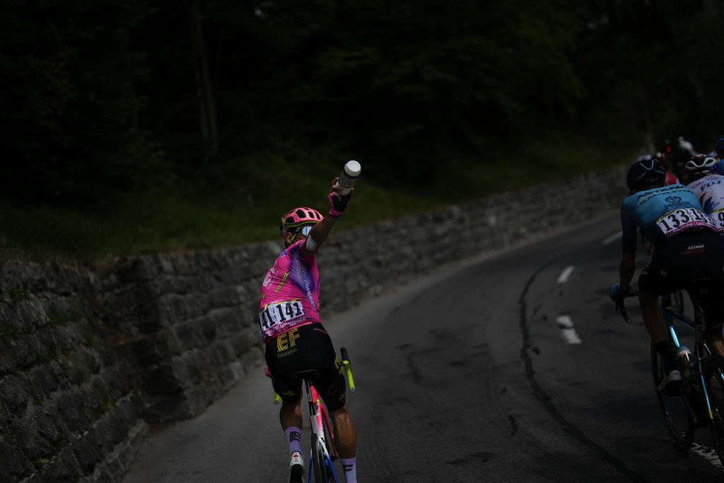 Pebalap Kolombia, Rigoberto Uran, memanggil mobil tim pendukungnya untuk meminta minum saat etape ke-9 Tour de France, 10 Juli 2022.