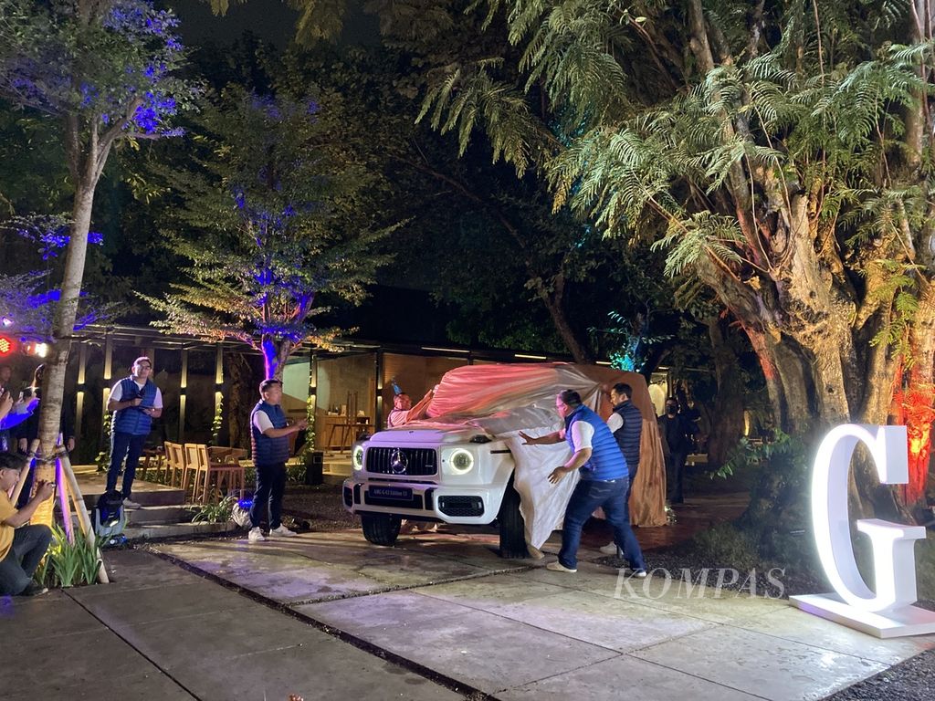 Para petinggi PT Mercedes-Benz Distribution Indonesia (MBDI) membuka selimut penutup mobil saat peluncuran Mercedes-AMG G 63 Edition 53 di Urban Forest, Jakarta Selatan, Jumat (10/2/2023) malam.