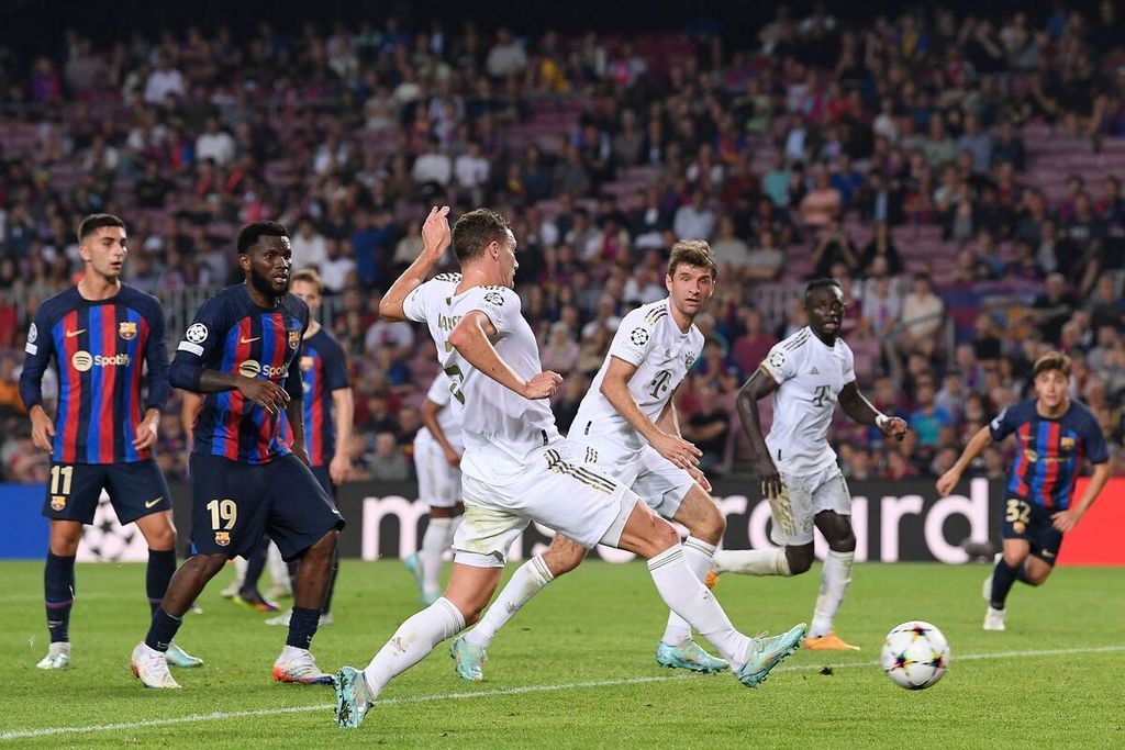 Pemain Bayern Muenchen Benjamin Pavard (tengah) mencetak gol ke gawang Barcelona pada laga Liga Champions di Stadion Spotify Camp Nou, Barcelona, Rabu (26/10/2022). Barcelona kalah 0-3 pada laga itu. 