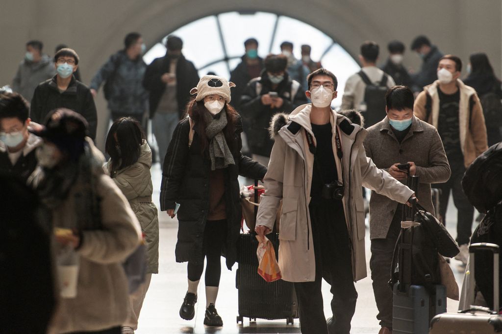 Penumpang berjalan dengan menggunakan masker di stasiun kereta Wuhan, Hubei, China, Sabtu (10/12/2022).  