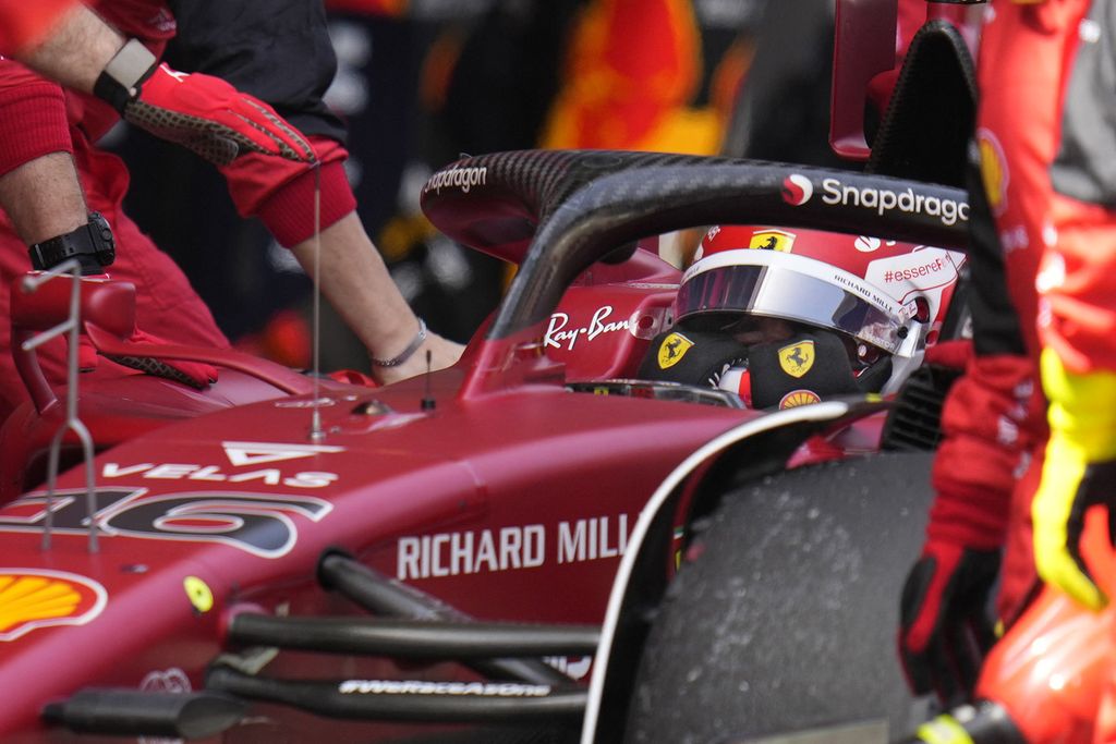 Pebalap Ferrari, Charles Leclerc, berusaha membuka helm setelah mobilnya kehilangan tenaga di lap ke-28 dan tak dapat melanjutkan balapan pada Grand Prix Formula 1 Spanyol di Circuit de Catalunya, Montmello, luar kota Barcelona, Minggu (22/5/2022). 