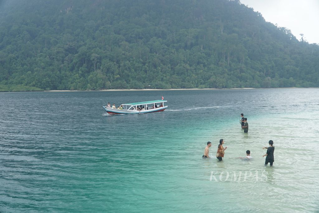 Para pengunjung bermain di sekitar perairan dangkal Pulau Pasumpahan, Kelurahan Teluk Kabung Selatan, Kecamatan Bungus Teluk Kabung, Kota Padang, Sumatra Barat, Minggu (8/10/2023). 
