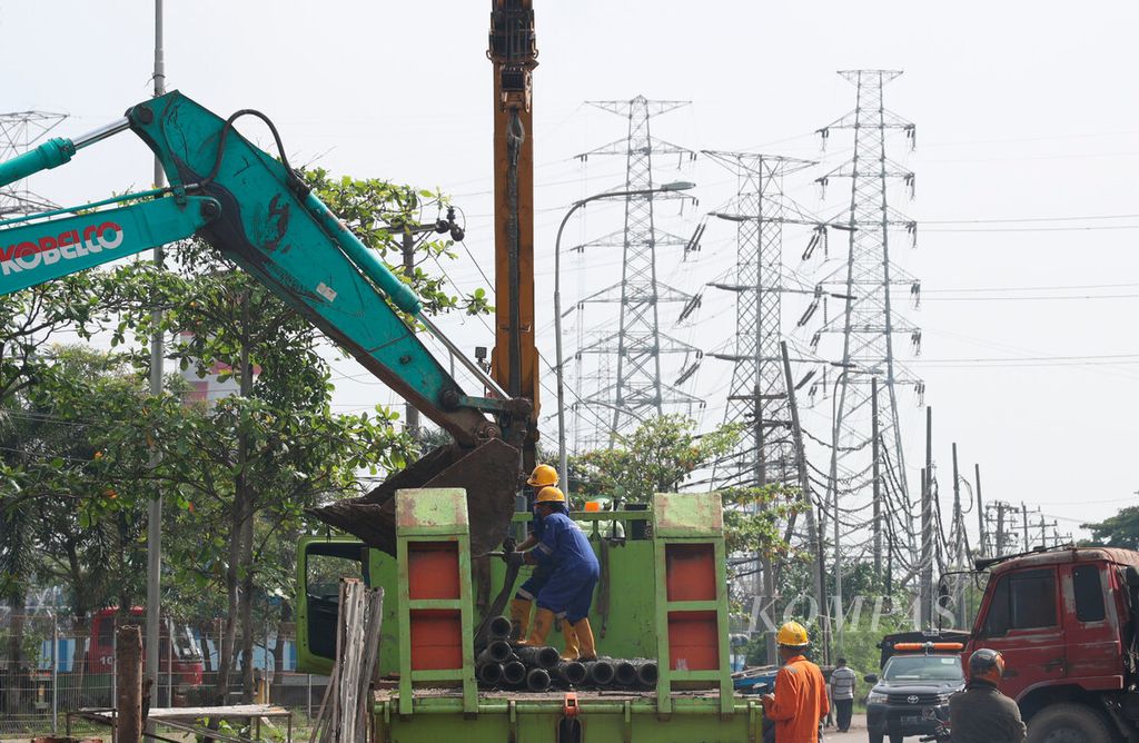 Pekerja membongkar muat peralatan pada proyek jalur pipa transmisi gas bumi di kawasan utara Kota Semarang, Jawa Tengah, Rabu (10/1/2023).
