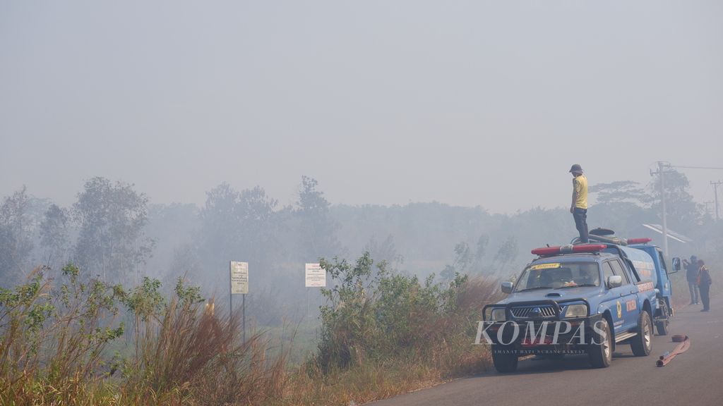Petugas dari Taruna Siaga Bencana (Tagana) Kalimantan Selatan berjuang memadamkan kebakaran lahan gambut di Kelurahan Syamsudin Noor, Kota Banjarbaru, Sabtu (7/10/2023). Pemadaman menjadi prioritas agar kabut asap tidak mengganggu penerbangan di Bandara Internasional Syamsudin Noor.