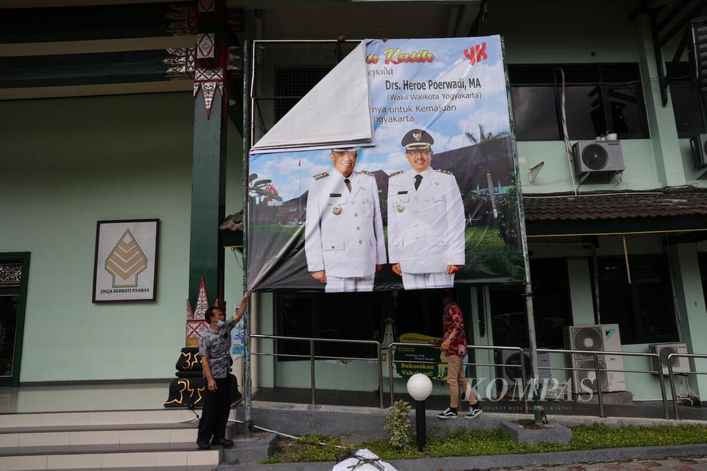 Pekerja melepas baliho bergambar eks Wali Kota Yogyakarta Haryadi Suyuti di kompleks Balai Kota Yogyakarta, Yogyakarta, Jumat (3/6/2022). 