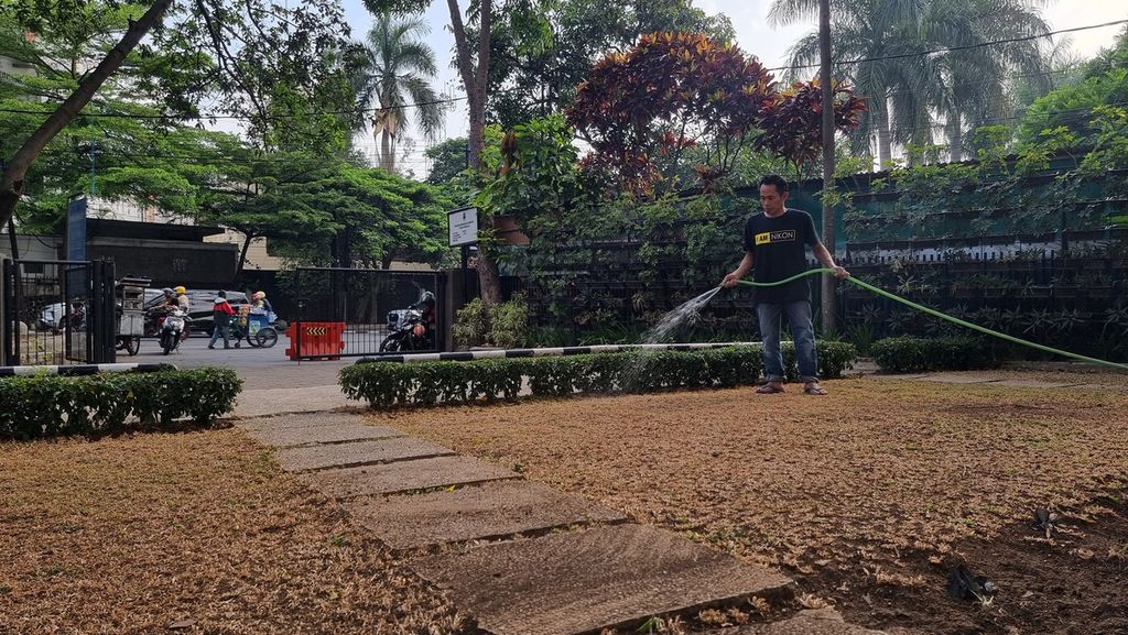 Seorang petugas taman menyiram rumput yang kering di salah satu halaman gedung di Kota Bandung, Jawa Barat, Jumat (6/10/2023).