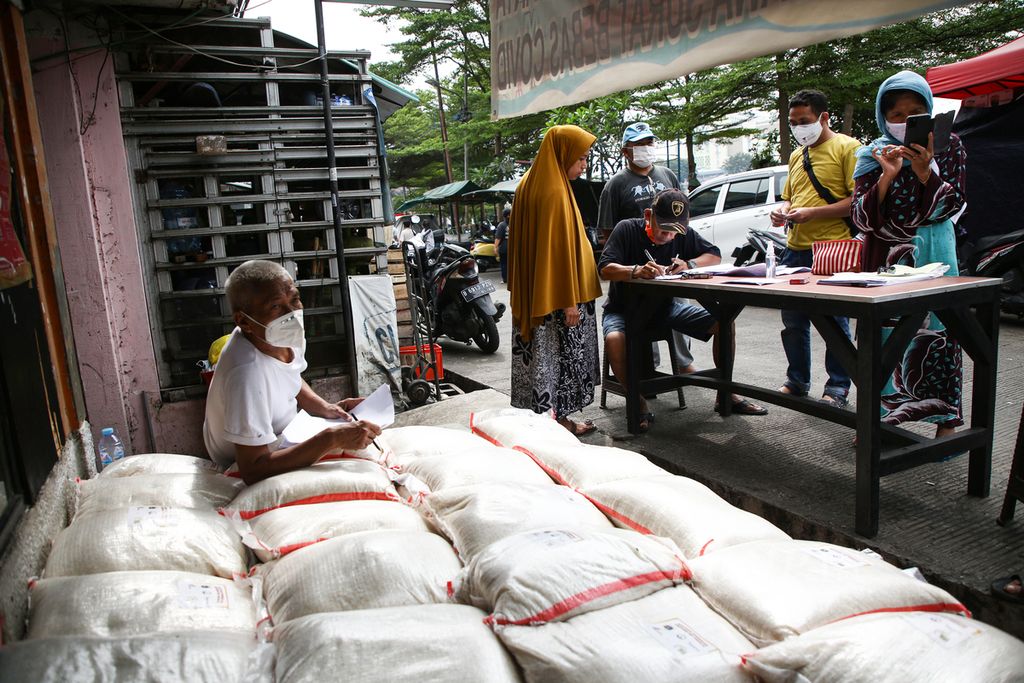 Warga mengambil bantuan beras di posko RW 001 Kelurahan Petamburan, Tanah Abang, Jakarta Pusat, Sabtu (31/7/2021).