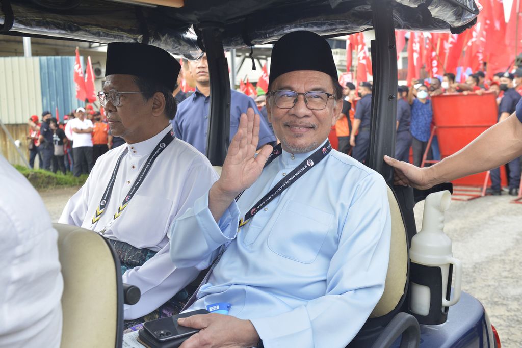 Tokoh oposisi Malaysia, Anwar Ibrahim, melambaikan tangan ke arah fotografer seusai mendaftarkan berkas pencalonan dirinya dalam pemilu di pusat pendaftaran di Tambun, Malaysia, Sabtu (5/11/2022). 