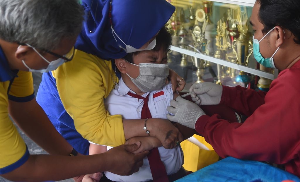 Siswa menangis saat divaksin tahap kedua di SD Negeri Kaliasin 1 Surabaya, Jawa Timur, Selasa (18/1/2022). Pemerintah kota terus menggenjot partisipasi vaksin anak secara lengkap untuk mendukung PTM 100 persen. Sebanyak 440 siswa ikut serta dalam vaksinasi tersebut. Beberapa anak baru mendapatkan vaksin pertama karena pada kesempatan sebelumnya sakit.