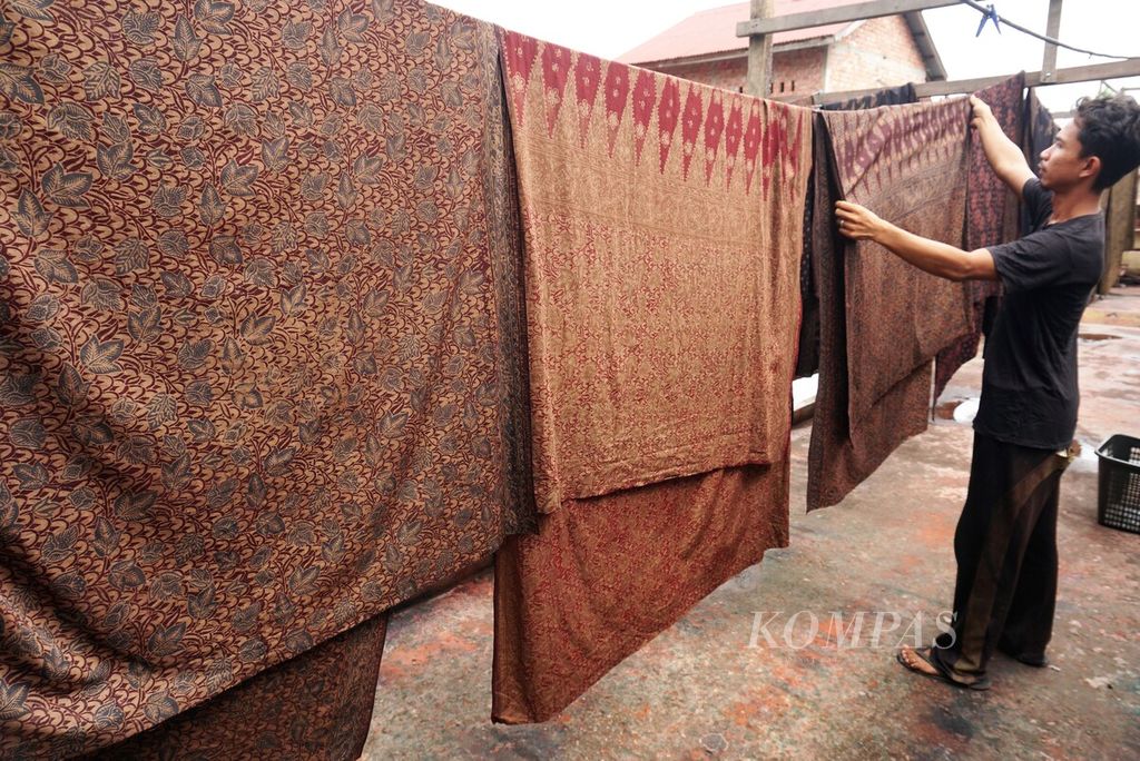 Perajin membubuhkan cap motif di atas lembaran kain di usaha kerajinan Batik Diana Jambi, Rabu (11/1/2023). Usaha batik yang semua tumbuh di kawasan Seberang Kota Jambi kini meluas ke berbagai daerah sekitar.
