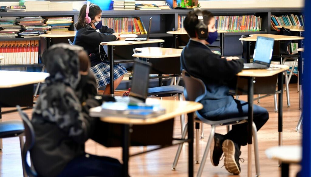 Para siswa menghadapi laptop di St Joseph Catholic School di La Puente, California, Amerika Serikat, 16 November 2020. 