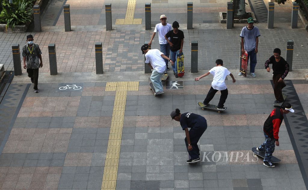 Skateboarders share space with pedestrians on the sidewalk of Sudirman-Thamrin street, Central Jakarta, Friday (12/3/2021).1