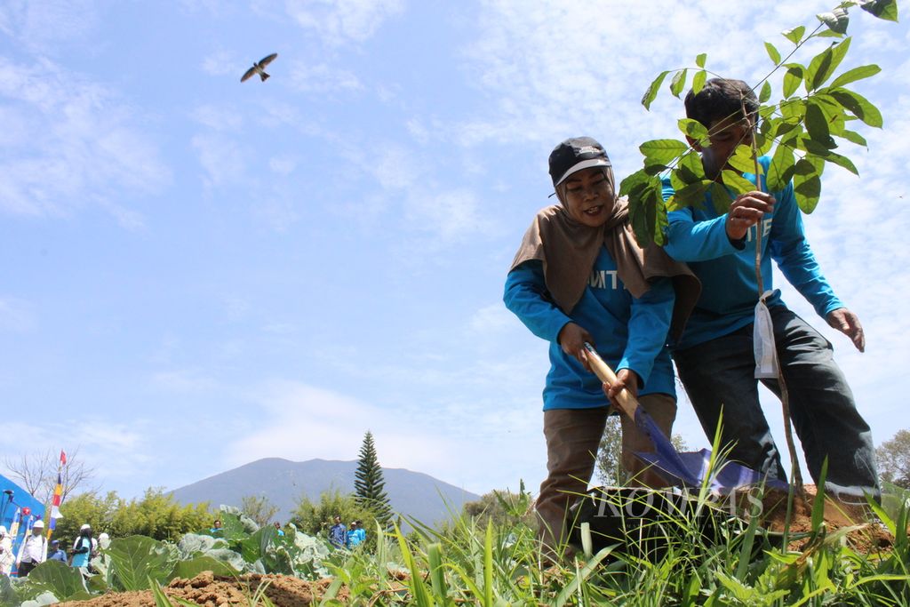 Warga RW 008 Kampung Karamat, Desa Sukamulya, Kecamatan Cugenang, menanam pohon di sekitar areal bak penampungan yang terletak di kaki Gunung Gede Pangrango di Cianjur, Jawa Barat. Warga berkomitmen ikut menjaga keasrian daerah sekitar demi menjamin ketersediaan air bersih.