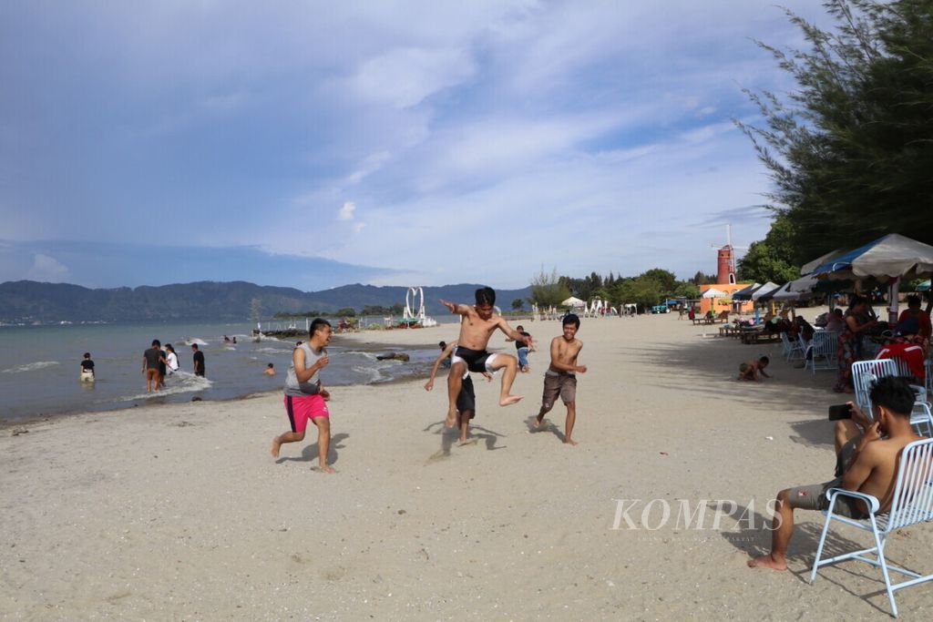 Wisatawan menikmati keindahan Danau Toba di Pantai Batu Hoda, Kecamatan Simanindo, Kabupaten Samosir, Sumatera Utara, Minggu (10/10/2021). 