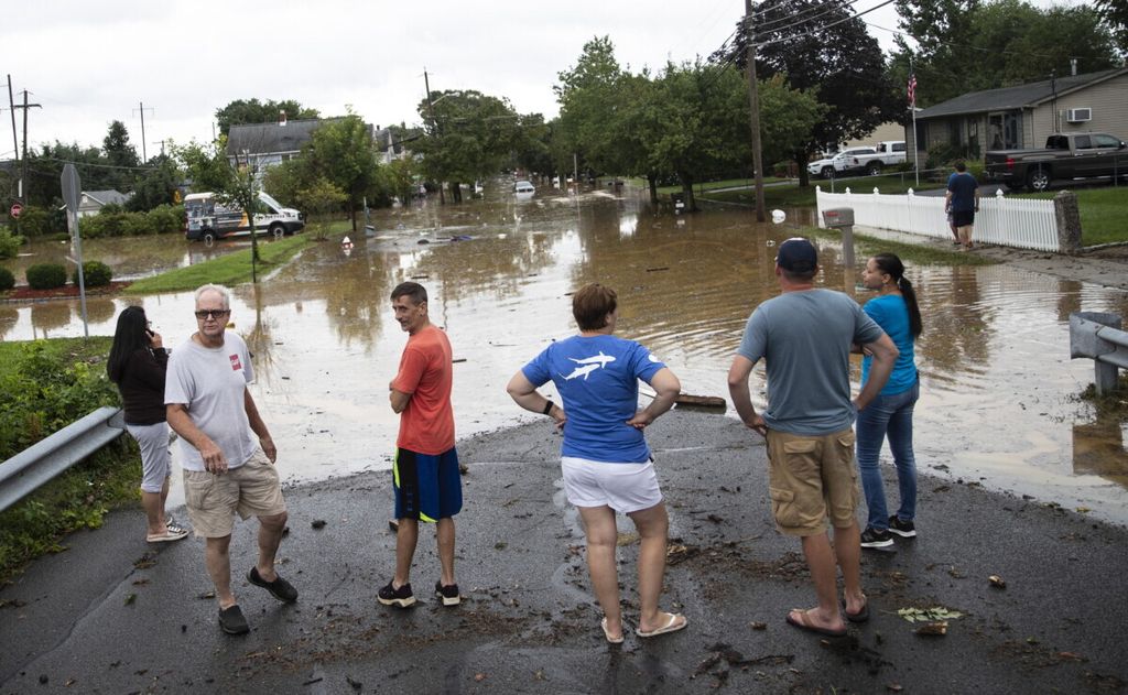Warga memeriksa kerusakan akibat banjir di sepanjang John Street setelah banjir bandang saat badai tropis Henri menyapu Helmetta, New Jersey, 22 Agustus 2021. 