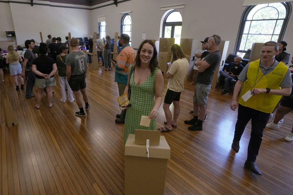 Seorang perempuan memasukkan surat suara ke dalam kotak suara di Redfern saat referendum di Sydney, Australia, 14 Oktober 2021. 