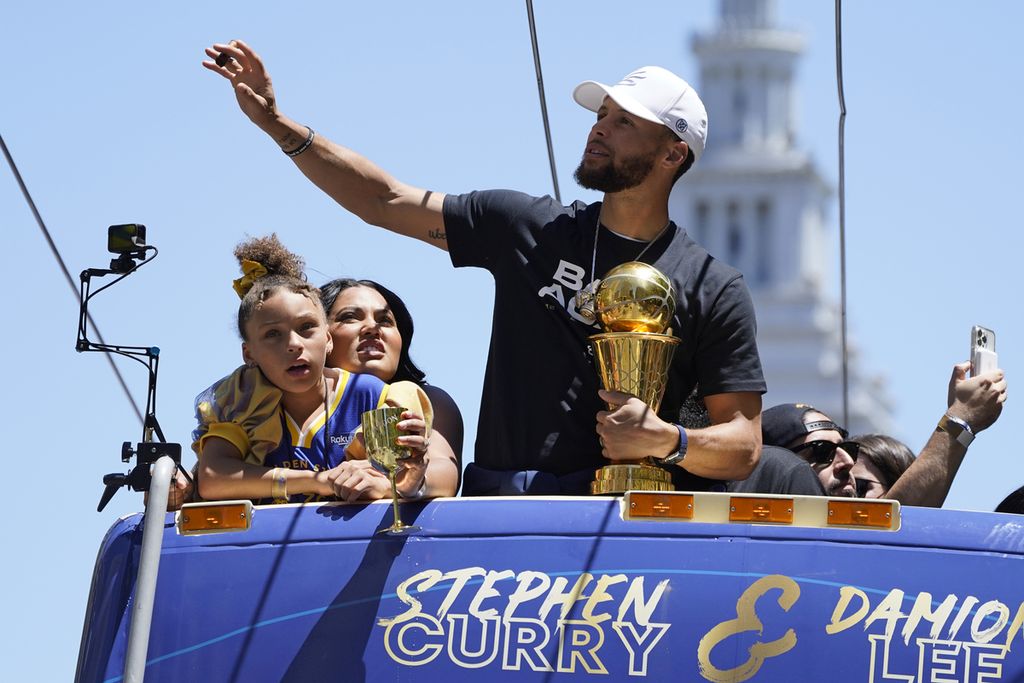 Stephen Curry, bintang Golden State Warriors (kanan), mengikuti parade trofi juara NBA di San Francisco, Amerika Serikat, Senin (20/6/2022). Stephen Curry juga sukses menyabet gelar MVP final NBA 2022.