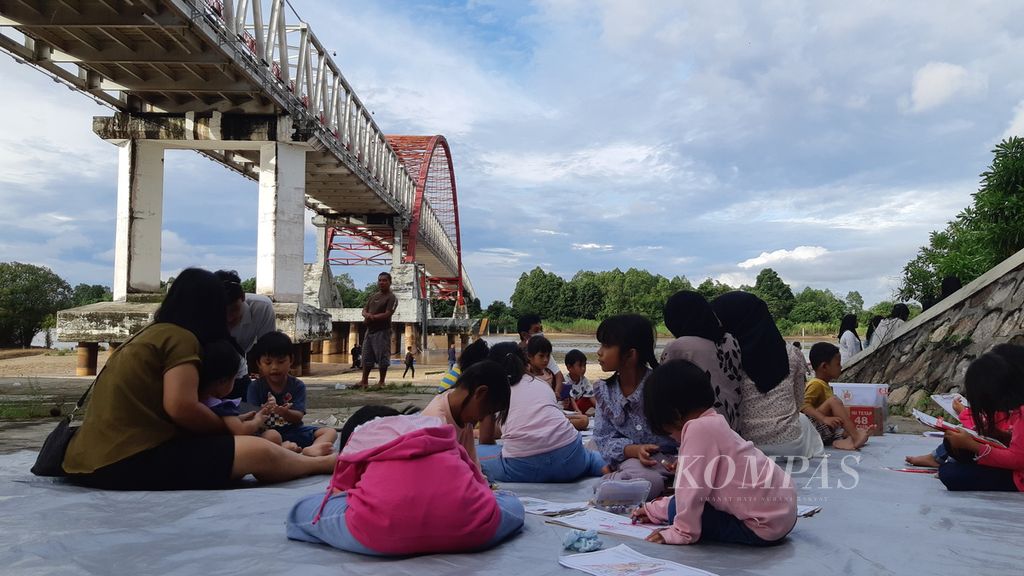 Di bawah jembatan Kahayan, Kota Palangka Raya, Kalimantan Tengah, pemuda Kalteng menggelar Sekolah Rakyat untuk anak-anak Kota Palangka Raya, Minggu (2/7/2023). 