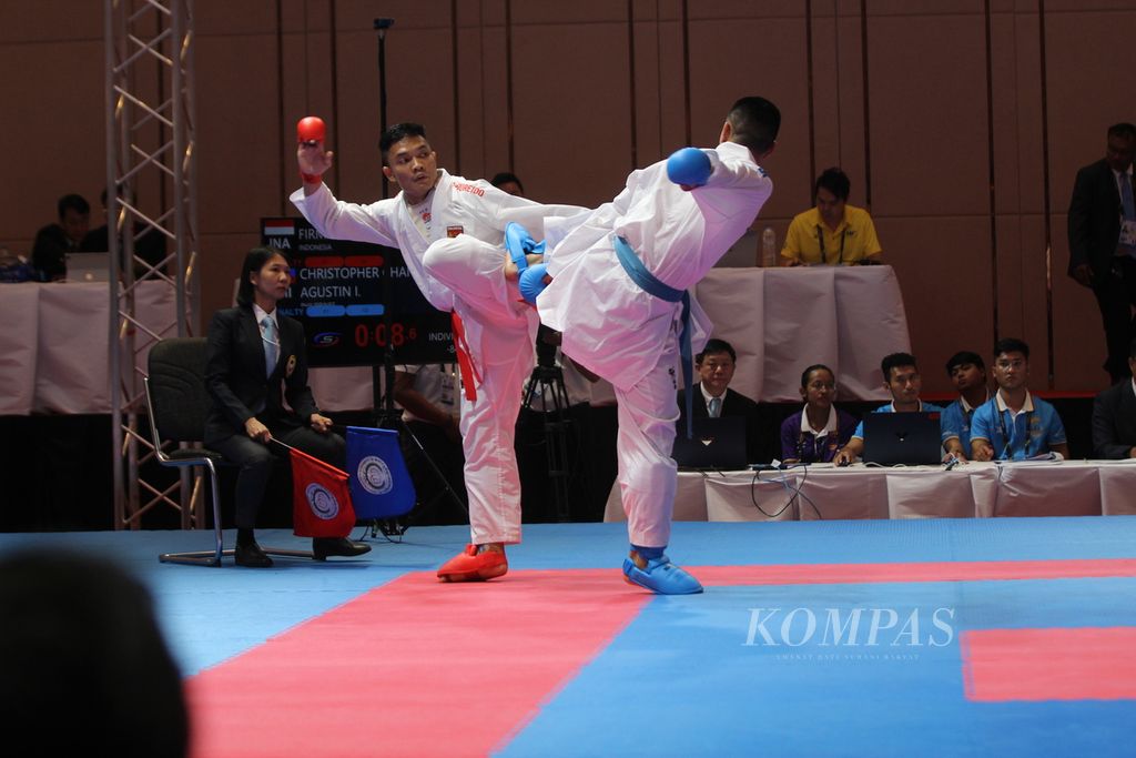 Sandi Firmansyah (kiri), karateka Indonesia, menahan tendangan lawannya asal Filipina di detik-detik terakhir pertandingan final karate putra nomor -84 kilogram di Chroy Changvar Convention Center, Phnom Penh, Kamboja, Minggu (7/5/2023). Sandi mendapatkan emas pertamanya di ajang itu.