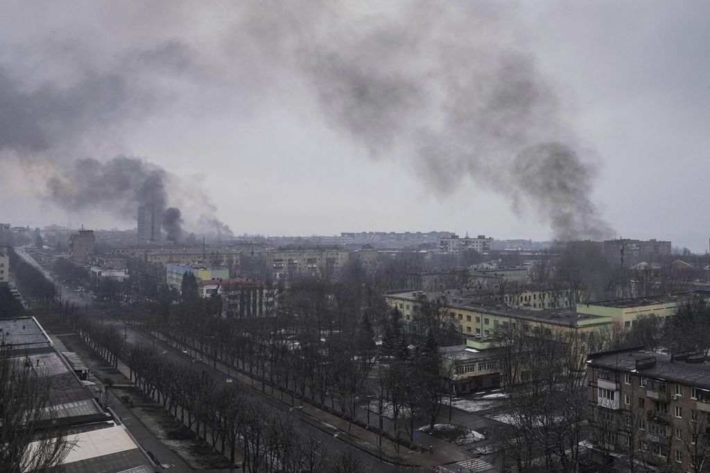 Asap mengepul seusai penembakan di Mariupol, Ukraina, Rabu (9/3/2022). Mariupol adalah kota pelabuhan berpenduduk 400.000 orang yang dikepung dan dibombardir oleh pasukan Rusia.