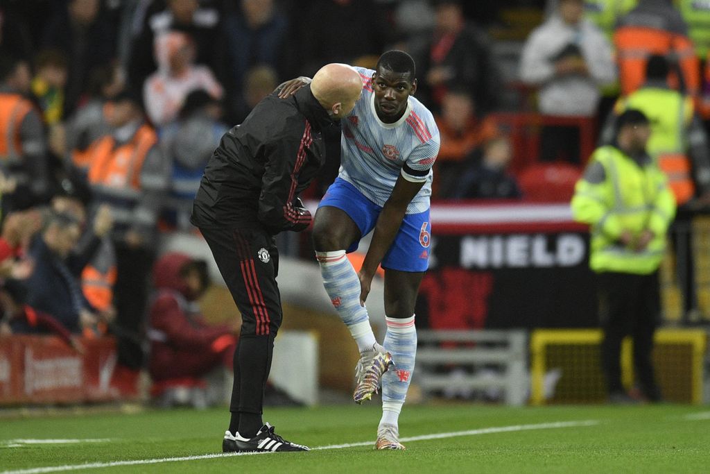 Paul Pogba (kanan) mengeluhkan kondisi kakinya saat masih membela Manchester United, April 2022 lalu. Pemain yang kerap didera cedera itu dipastikan absen membela Perancis di Piala Dunia Qatar 2022 akibat cedera lutut.