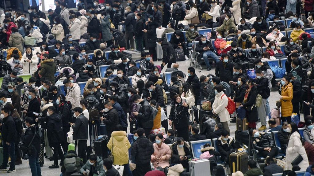 Orang-orang menunggu untuk naik kereta di Stasiun Kereta Api Hangzhou Timur, Hangzhou, Provinsi Zhejiang, China, Kamis (28/1/2021). Mereka akan menuju kampung halaman mereka untuk merayakan Tahun Baru Imlek.
