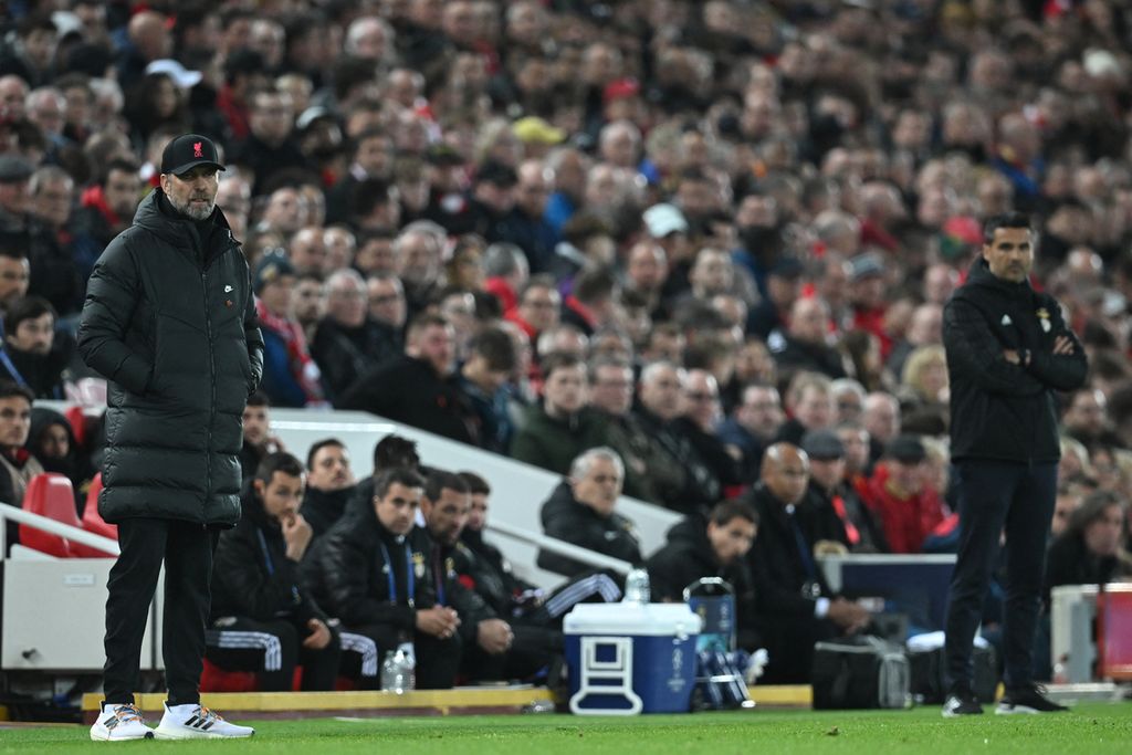 Manajer Liverpool Juergen Klopp (kiri) dan Pelatih Benfica Nelson Verissimo mengamati jalannya pertandingan dalam babak perempat final putaran kedua Liga Champions Eropa di Stadion Anfield, Liverpool, Inggris, Kamis (14/4/2022) dini hari WIB.