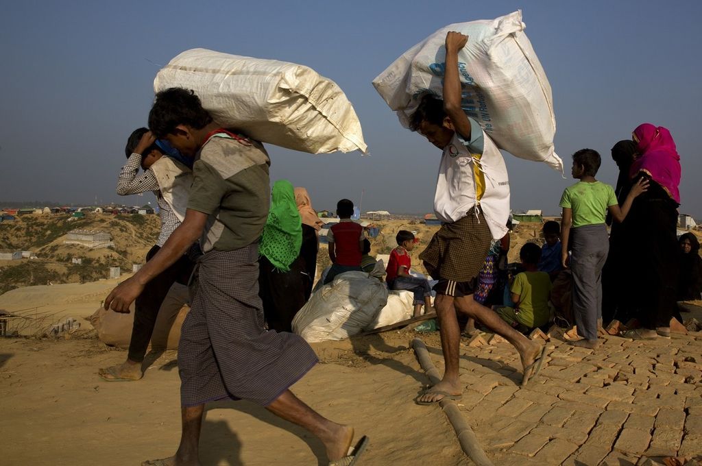 Foto yang diambil pada 24 Januari 2018 ini memperlihatkan sejumlah warga Rohingya membawa barang saat memasuki sebuah kawasan di Bandarban, yang berada di perbatasan Myanmar dan Bangladesh.